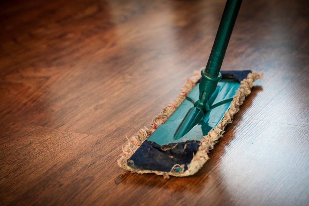 brown-wooden-floor-48889 A detailed view of a mop cleaning a wooden floor, showing texture and pattern.